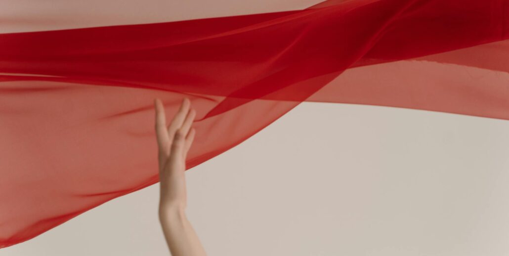 woman hand with red fabric on white background